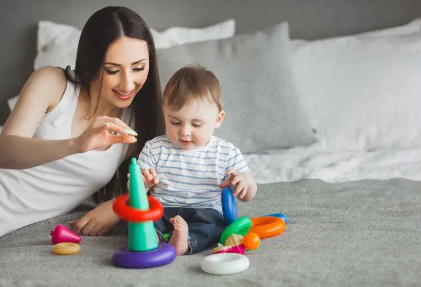 young mother playing blocks with her baby